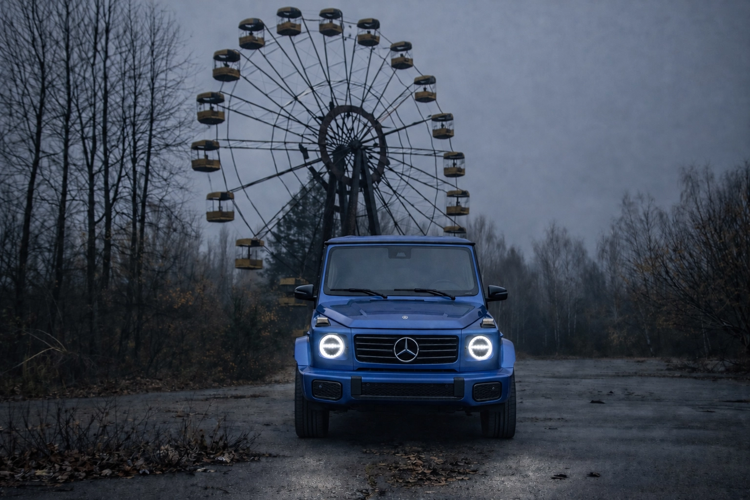 Blue Mercedes-Benz G-Class with headlights on in front of an abandoned Ferris wheel
