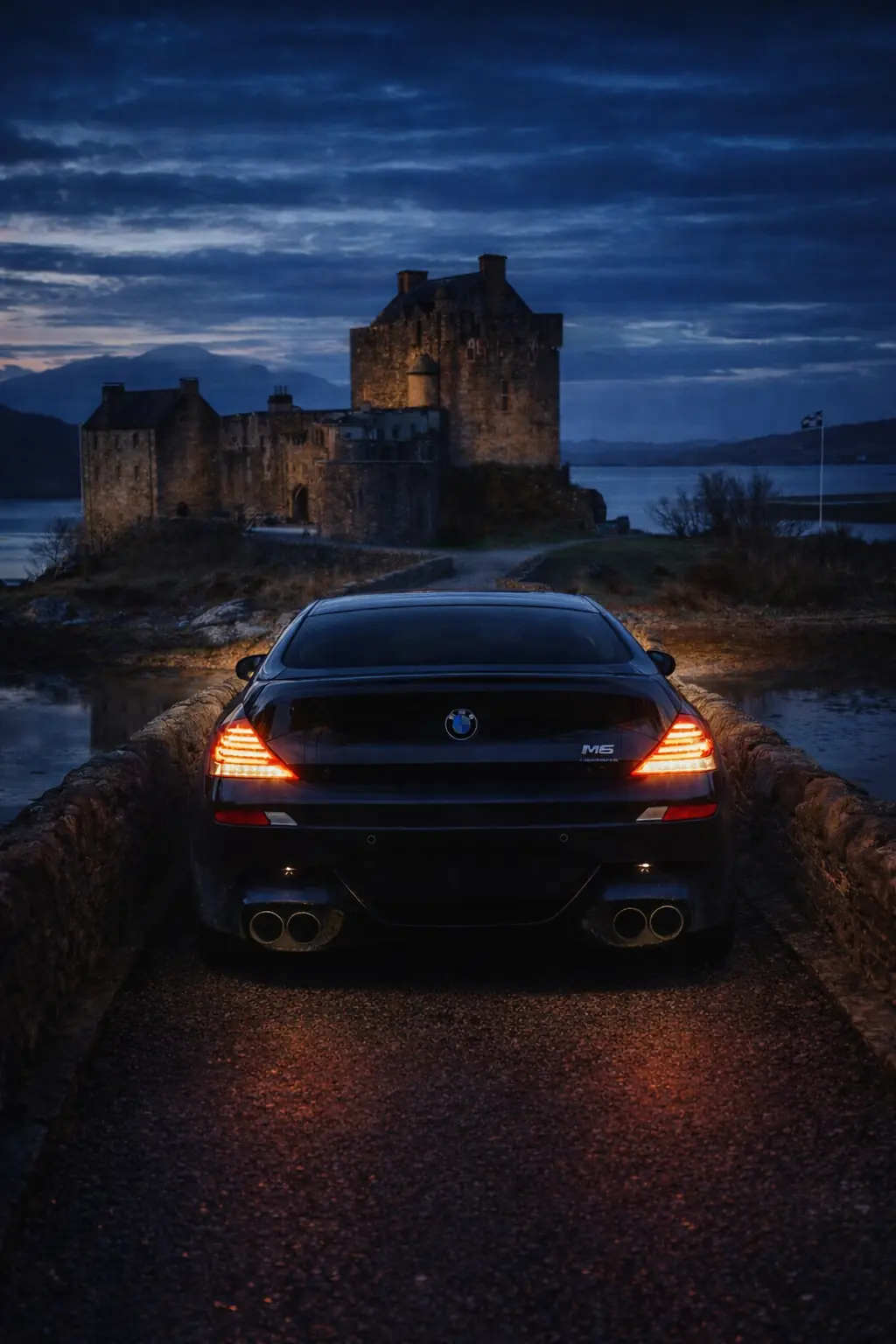 Black BMW M6 on the bridge to a Scottish castle at blue hour