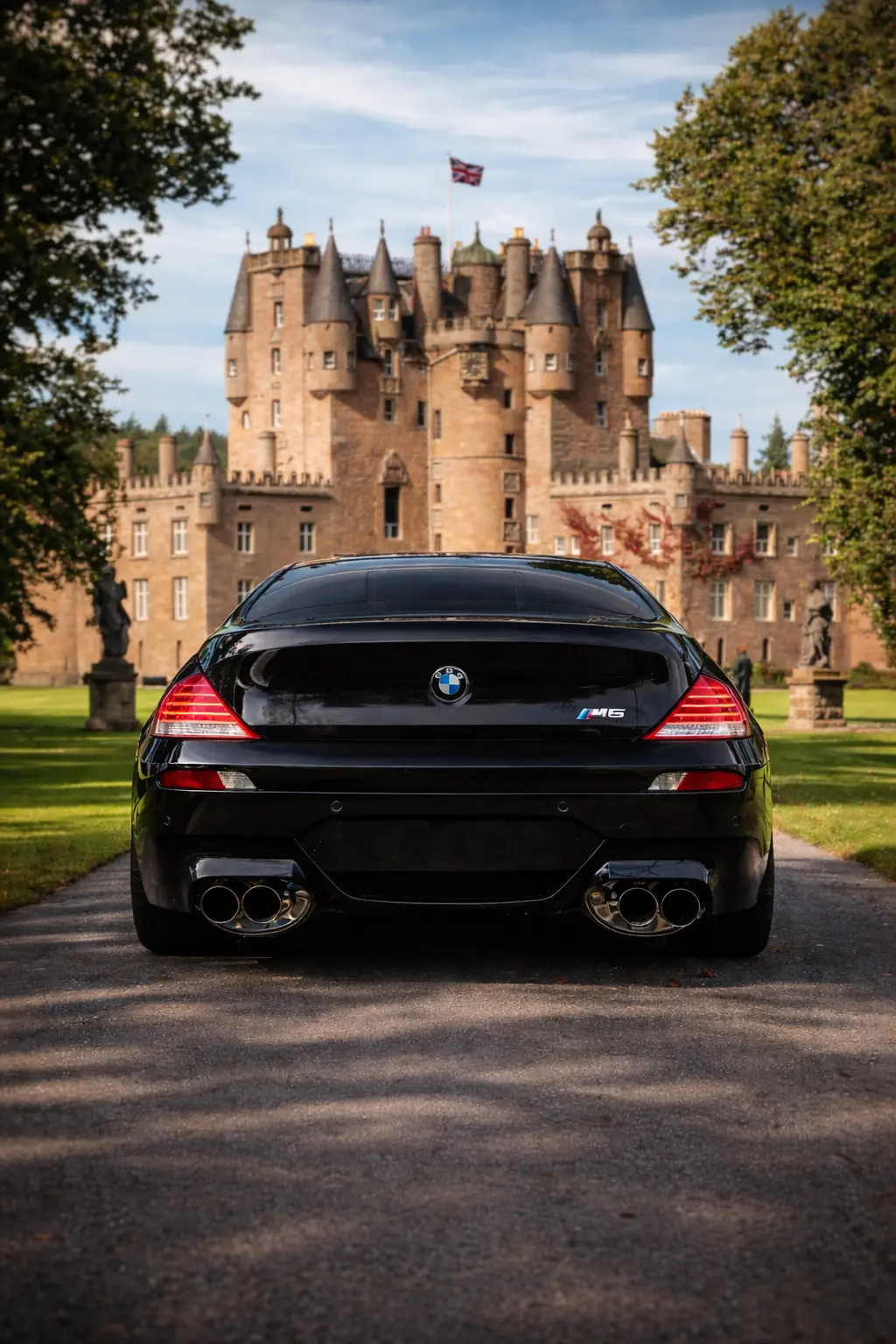 Black BMW M6 on a drive in front of a sandstone castle